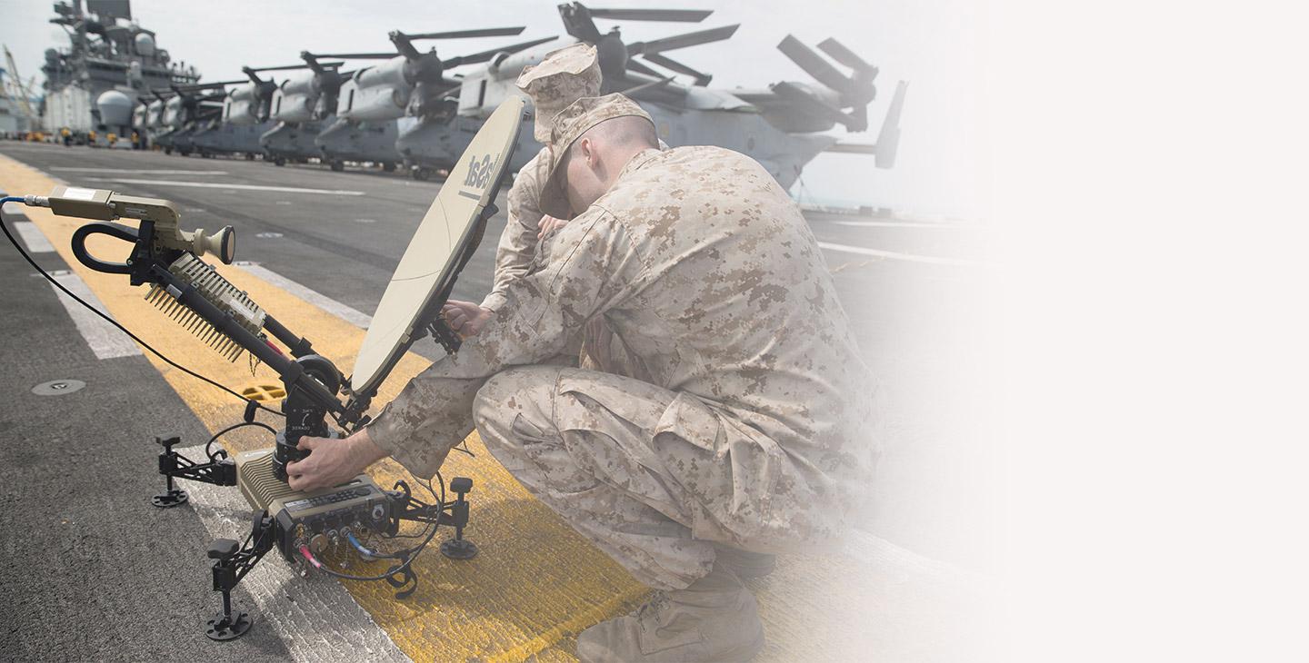 Two warfighters setting up Viasat's Multi-Mission ground terminal on an aircraft carrier